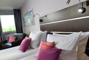 科隆胡加尔尼高级酒店的酒店的客房 - 带粉红色和白色枕头的床