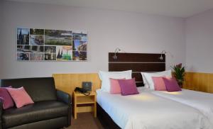 科隆胡加尔尼高级酒店的酒店客房,配有两张床和椅子