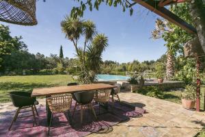 迈兹Domaine Sesquier Mas d'exception Acacia的一个带桌椅的庭院和一个游泳池