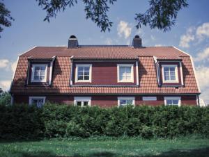 耶夫勒Gavle Apartments Hotel - Lexegränd的红色的房子,设有瓷砖屋顶