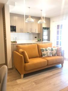 索特Apartament Neret II的客厅里配有橙色沙发,设有厨房