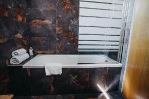 克雷姆尼察维扎旅馆的带浴缸的浴室和窗户。