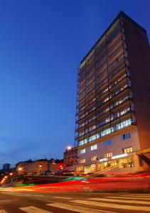 里耶卡奈波德酒店的一座高大的建筑,前方有一条街道