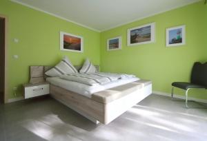 普特布斯Ferienhaus Annemiete的一间卧室设有一张带绿色墙壁的床