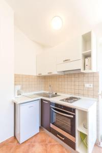 韦伯斯卡Apartments Seric的白色的厨房配有炉灶和水槽