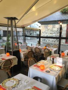 翁弗勒尔Appartement de L'Escale的餐厅配有白色的桌椅和橙色的椅子