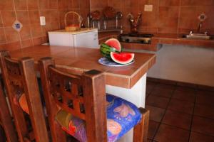 塔帕尔帕米森鲁那萨克拉宾馆的厨房配有一张桌子,上面放着一碗西瓜