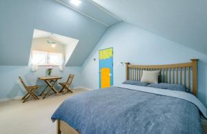 济州市Atempause的蓝色卧室,配有床和桌子
