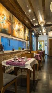 阿尔玛格鲁Hotel Boutique Arte y Descanso的餐厅设有桌椅,墙上挂有绘画作品
