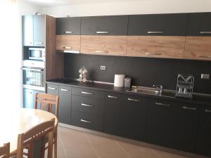 巴尔奇克Апартамент Явор的厨房配有黑色橱柜、水槽和桌子