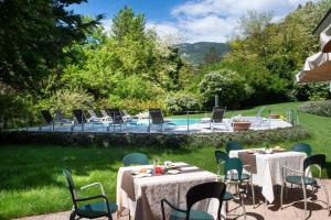 科马诺泰梅Vital Hotel Flora的一个带桌椅的庭院和一个游泳池