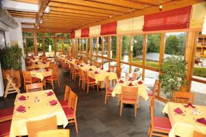 玛丽亚阿尔姆马可·波罗家庭运动酒店的餐厅设有桌椅和窗户。