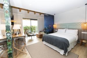 里瓦德奥米娜尔特酒店的一间带一张大床和一张书桌的卧室和一间房间