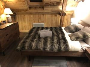特拉松Les Maisons du Périgord的一间卧室配有一张床铺,床上有毯子