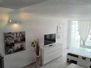 美洲海滩柏林根私人住宅公寓的一间白色卧室,配有电视和白色梳妆台