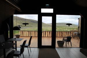 Hlíð í HörðudalDalahyttur的客房享有带桌椅的甲板的景致。