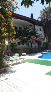 安塔利亚卡莱亦奇欧资卡夫客酒店的一座房子,设有游泳池,并摆放着椅子和鲜花