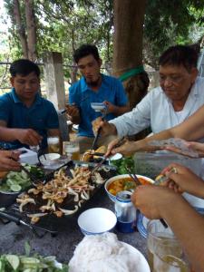 永熙Khách sạn Mộng An的一群坐在桌子旁吃食物的人