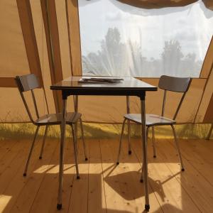 赫鲁德VierVaart Tent的窗前的两把椅子和一张桌子