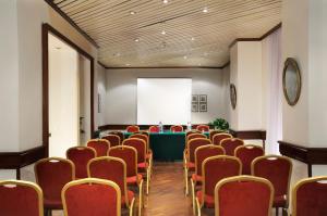 罗马托瑞诺酒店的一间会议室,配有红色椅子和白色屏幕