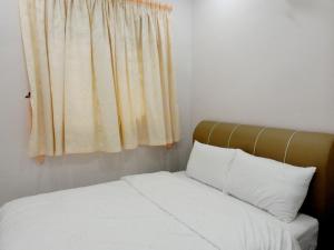 太平Taiping Cozy Homestay II的一间卧室配有一张带白色床单的床和一扇窗户。
