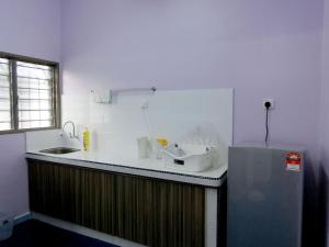 太平Taiping Cozy Homestay II的厨房配有带水槽的柜台和冰箱。