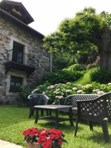 佩琼Posada Fuentedevilla的院子里放着鲜花,放着两把长椅和一张桌子