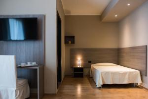 蒙泰贝卢纳阿尔贝格格拉波罗德奥罗酒店的一间卧室配有一张床和一台平面电视