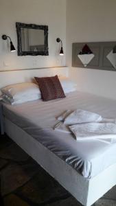 斯科派洛斯蓝色巨人酒店的卧室内的一张大白色床,配有镜子