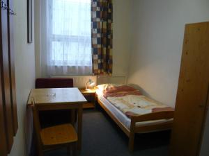布拉格哈萨酒店的小房间设有床、桌子和窗户
