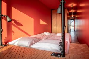 瓦尔内明德DOCK INN Hostel Warnemünde的红色墙壁的房间里一张床位