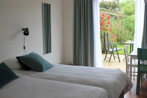 德科赫Bluesheep-texel的一间卧室设有两张床,享有庭院的景色