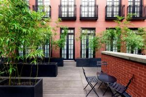 纽约美世酒店的建筑前方的庭院,庭院里摆放着椅子和植物