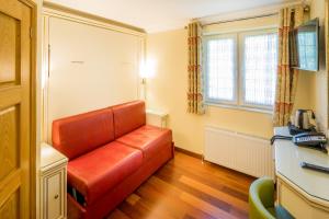 卢顿Linton Hotel Luton的客厅配有红色皮沙发
