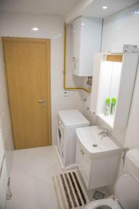 萨拉热窝Leader apartment的白色的浴室设有卫生间和水槽。