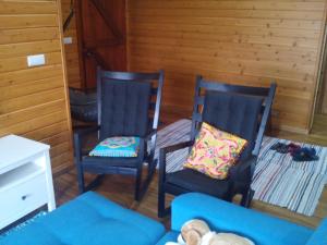 富尔纳斯Casa dos Manos的客厅配有两把椅子和一张沙发
