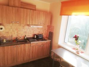 派尔努Couple getaway to a freshly renovated apartment的厨房配有木制橱柜、水槽和窗户。