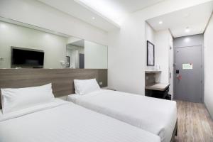 马尼拉Red Planet Manila Binondo的一间酒店客房,设有两张床和电视