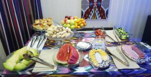 撒马尔罕Jahongir Guest House的桌上放着一碗水果和盘子