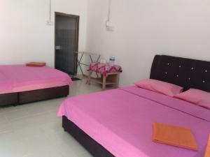 瓜拉大汉德利马旅馆的配有粉红色床单的客房内的两张床