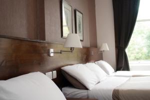 爱丁堡Edinburgh House Hotel的酒店客房设有两张床和窗户。