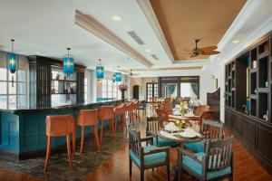 海防马尼奥尔德斯阿尔斯酒店的餐厅设有酒吧和桌椅