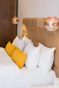 阿拉木图哈萨克斯坦酒店的一张配有白色和黄色枕头的床