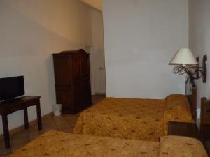 瓦哈卡市安缇格福廷酒店的酒店客房配有床、沙发和电视。