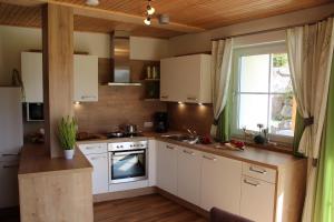 格伦Am Schwand的厨房配有白色橱柜、水槽和窗户。
