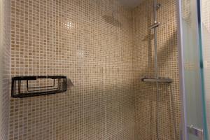 拉梅特拉·德·玛尔INNOUTHOME Apartamento Ramón y Cajal II的带淋浴的浴室和棕色瓷砖墙壁