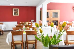 辛根猎人酒店的一间带桌椅和鲜花的用餐室