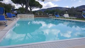 加沃拉诺La Locanda della Vecchia Hosteria的一个带蓝色椅子和桌子的大型游泳池