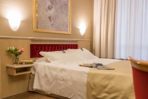 圣多纳托-米拉内塞桑塔芭芭拉酒店的酒店客房,配有一张红色床头板的床