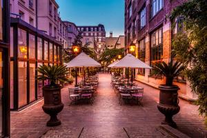 巴黎马莱公园酒店的一条带桌椅和遮阳伞的空街道